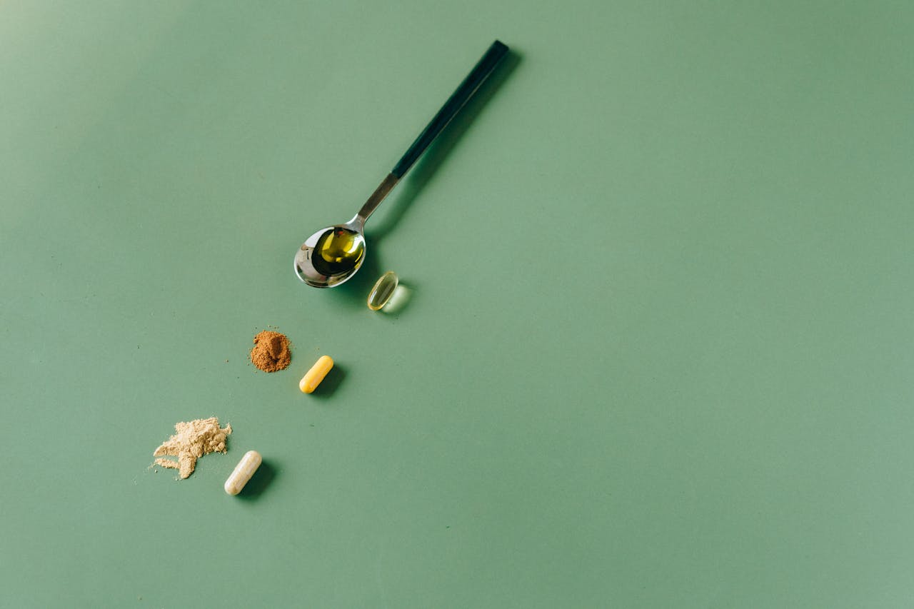 about-us Assorted herbal supplements and powders on a green backdrop with a spoon.